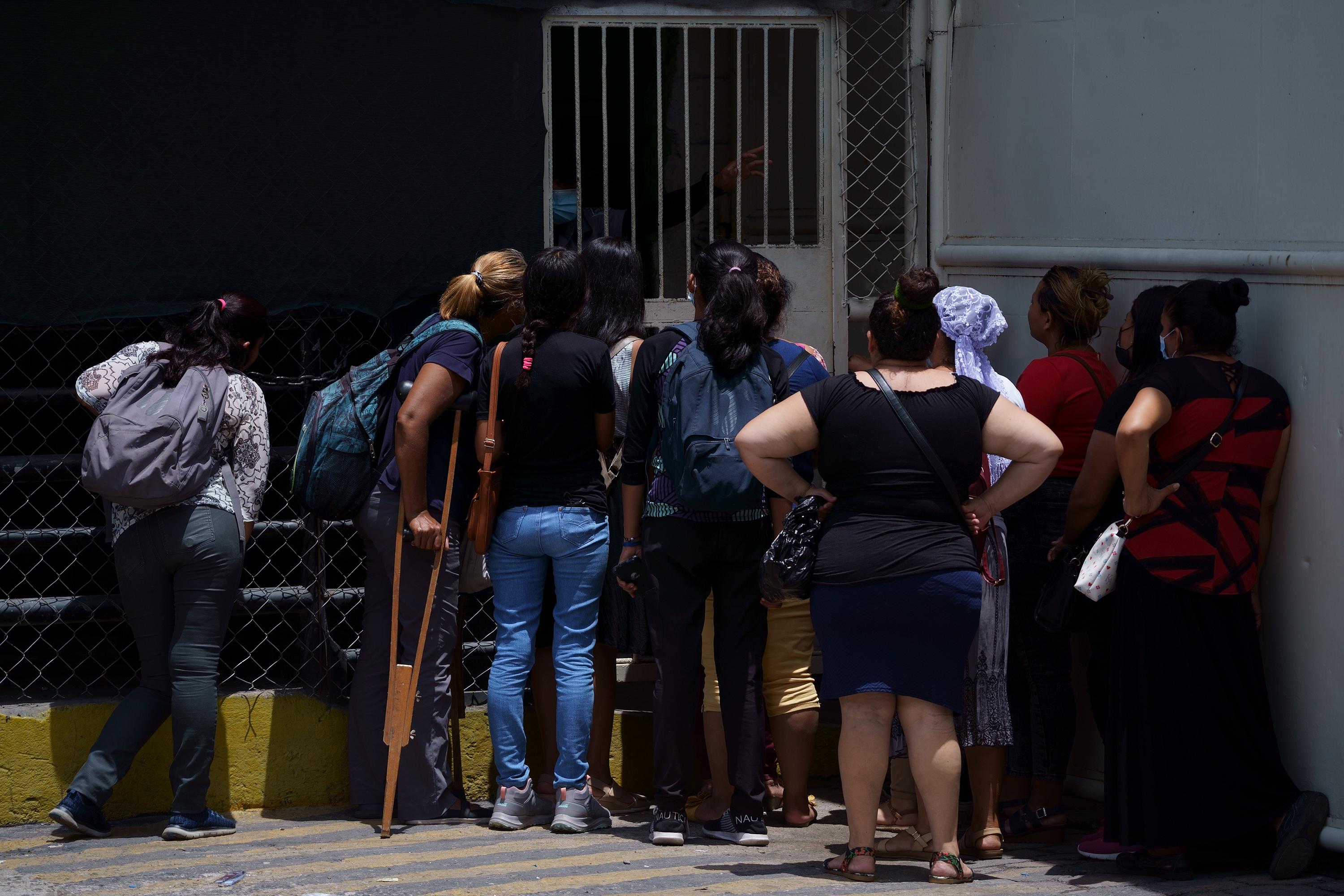 Women ask for information about their detained relatives at the main gate to Mariona Prison. The scarce information on detainees during the state of exception has drawn large crowds outside of prison facilities. Photo: Víctor Peña/El Faro