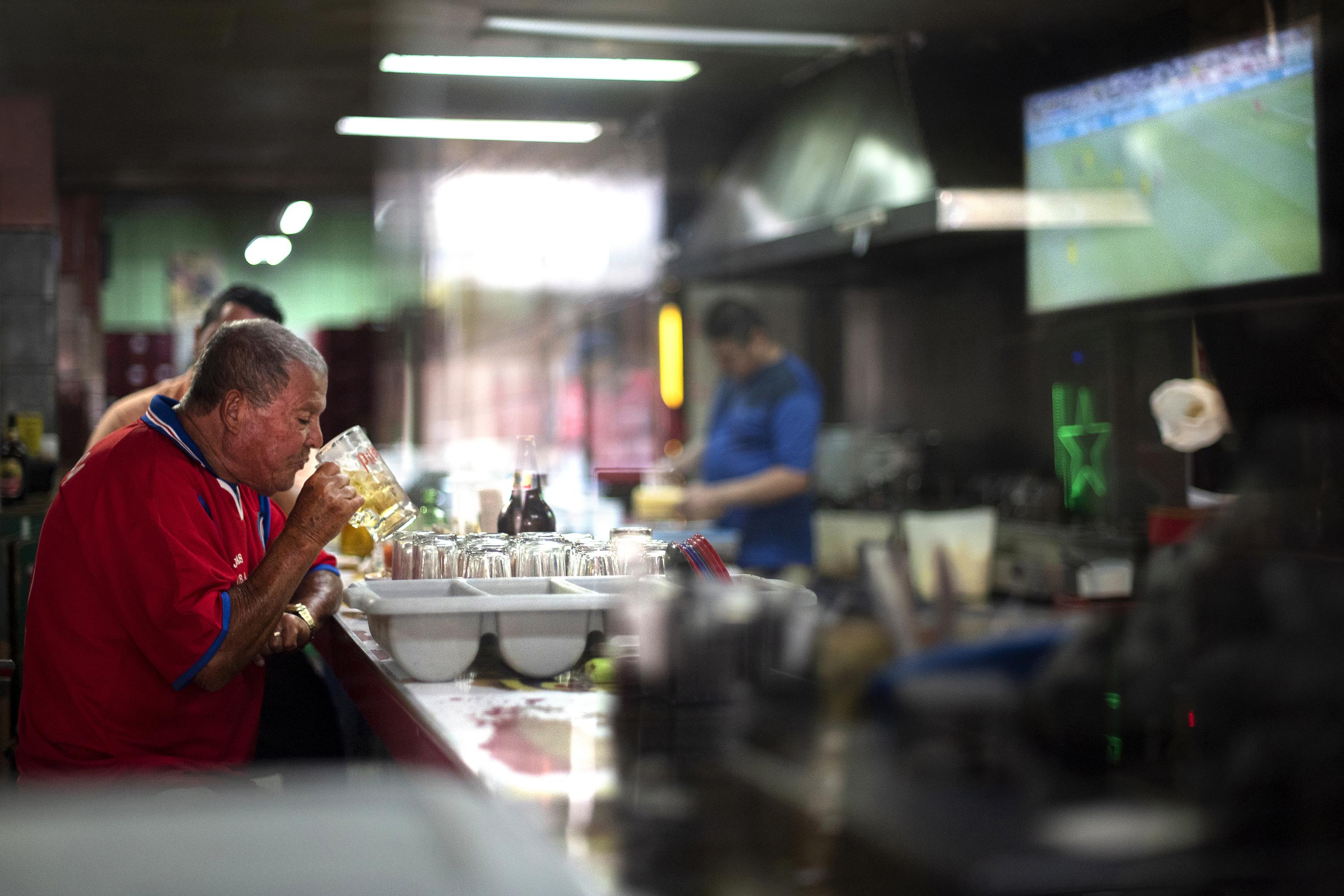Costa Rica llama “guaro”, en general, a aquellas bebidas que Qatar prohíbe a su gente y restringe a los extranjeros, incluso en días de fútbol y patrocinios multimillonarios.  En la Avenida 1 de San José, un antiguo y popular bar llamado La Embajada es un área excepcional para las órdenes del emirato y en la noche de la inauguración de la Copa del Mundo este hombre identificado con el apodo: 'Carajillo' lo aprovecha.  El apodo significa 