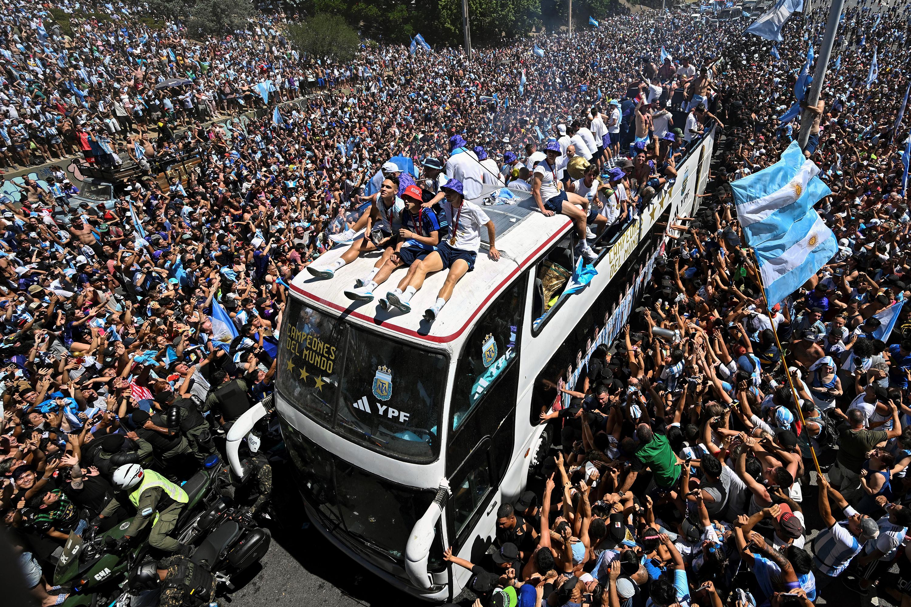 Los fanáticos de Argentina animaban mientras el equipo desfila a bordo de un autobús después de ganar el torneo de la Copa Mundial de Qatar 2022. (Foto por Luis ROBAYO / AFP).