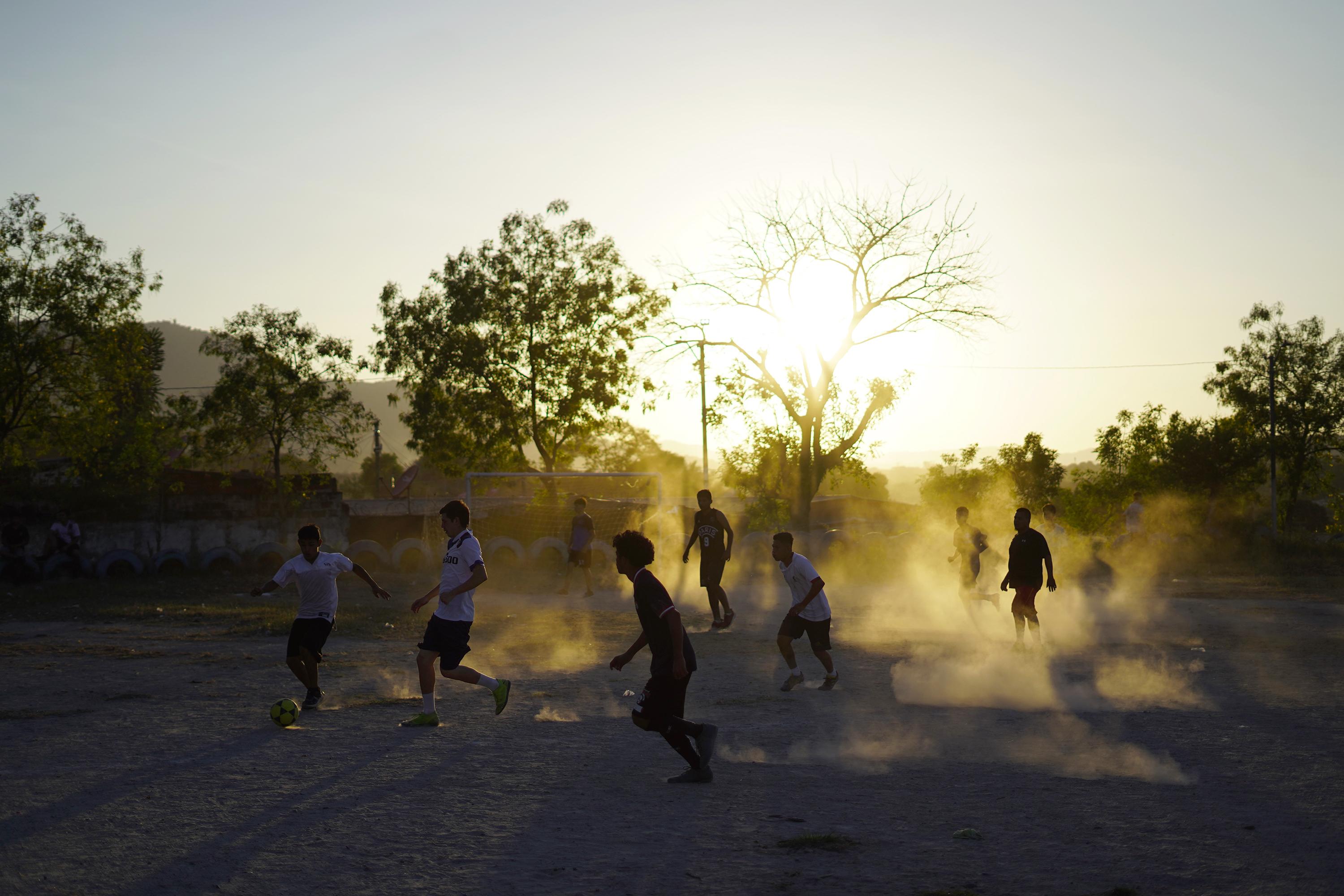 Los habitantes del reparto Las Cañas, en el municipio de Ilopango, juegan al fútbol en la vieja que cancha que por muchos años fue una frontera entre la MS-13 y el Barrio 18 Sureños. Los habitantes ahora luchan por unificar a la comunidad. Foto de El Faro: Víctor Peña.