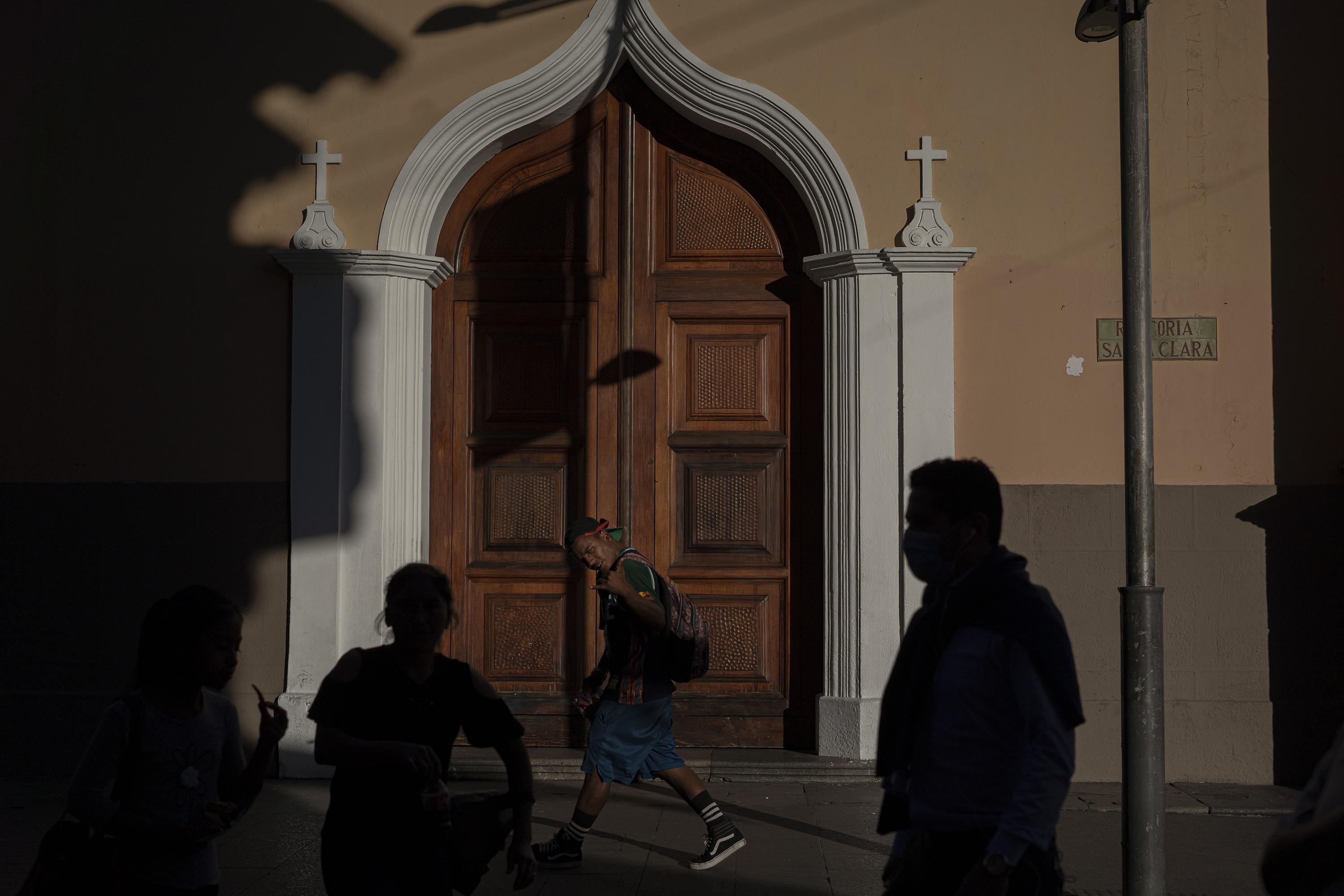 Yonaiker de Jesús Arévalo Ortiz, 20, strides down Sixth Avenue, the pedestrian walkway in the center of Guatemala City. Yonaiker is from Puerto Cabello, a city in the state of Carabobo, Venezuela. Like many Venezuelans in the city, he sells candy every day to buy a meal and find a place to sleep. Photo: Víctor Peña/El Faro