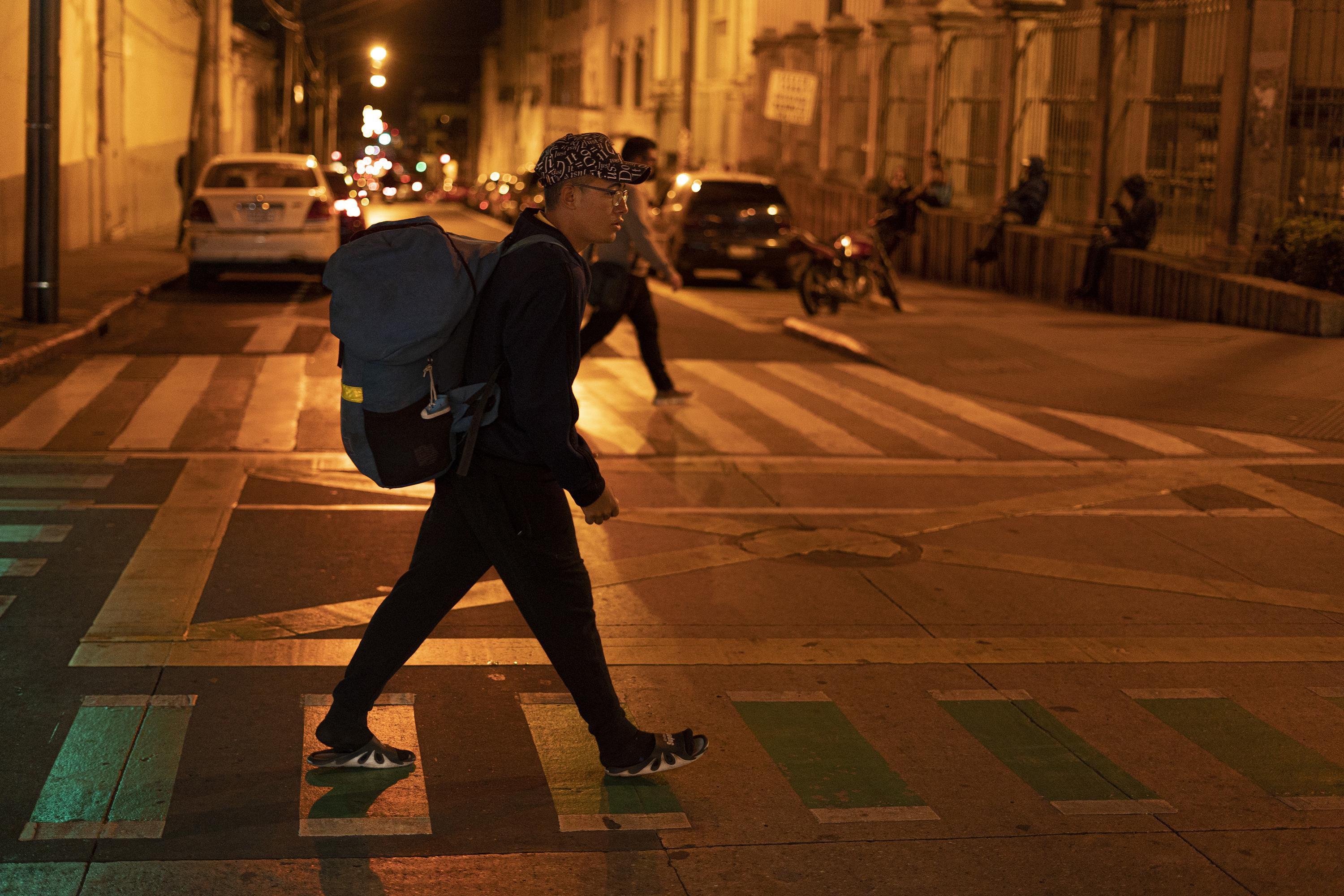 Juan walks down Sixth Avenue toward his hotel after a long day of work in the center of Guatemala City. Photo: Víctor Peña/El Faro