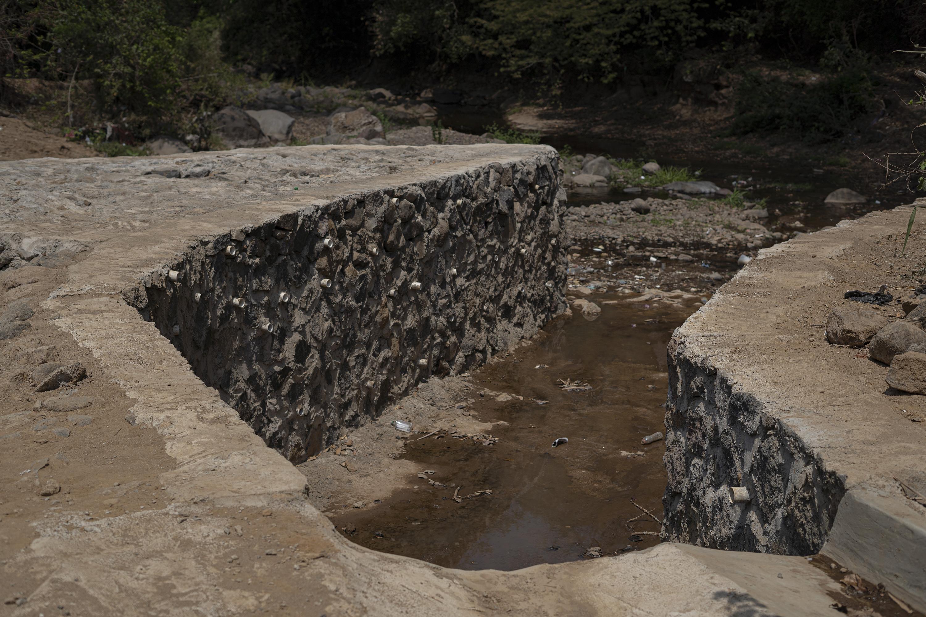 Las aguas residuales de las 1,764 casas que construye la empresa Fénix desembocan en el río Escalante, en Ahuachapán. La empresa construyó un canal de al menos 700 metros de longitud para transportar sus desechos hasta el río que abastece a las comunidades de los alrededores. Foto de El Faro: Víctor Peña. 