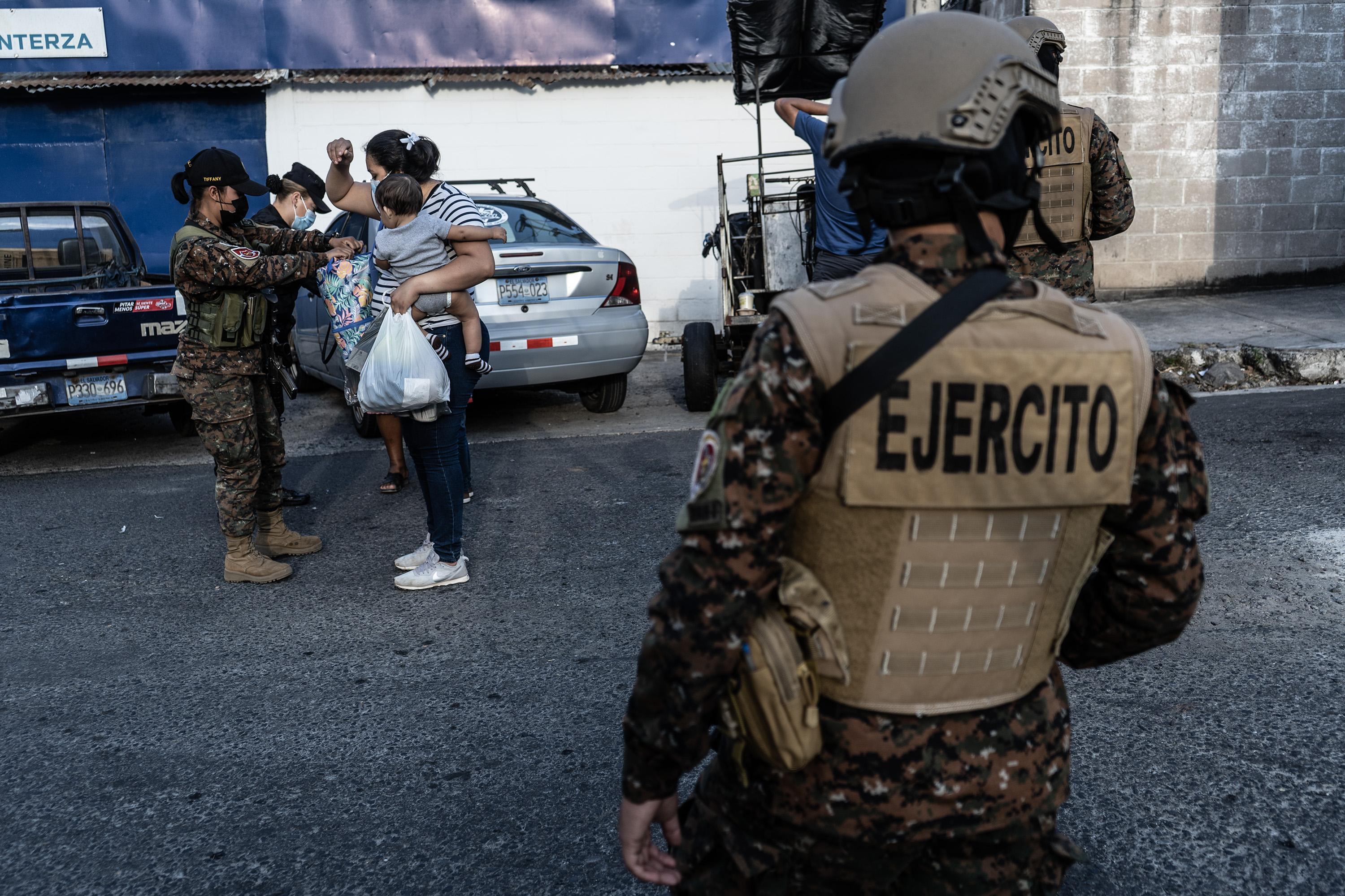 Miembros del Ejército revisan a una residente de la comunidad San José El Pino, Santa Tecla, durante el inicio del régimen de excepción, el 27 de marzo de 2022. Foto de El Faro: Carlos Barrera