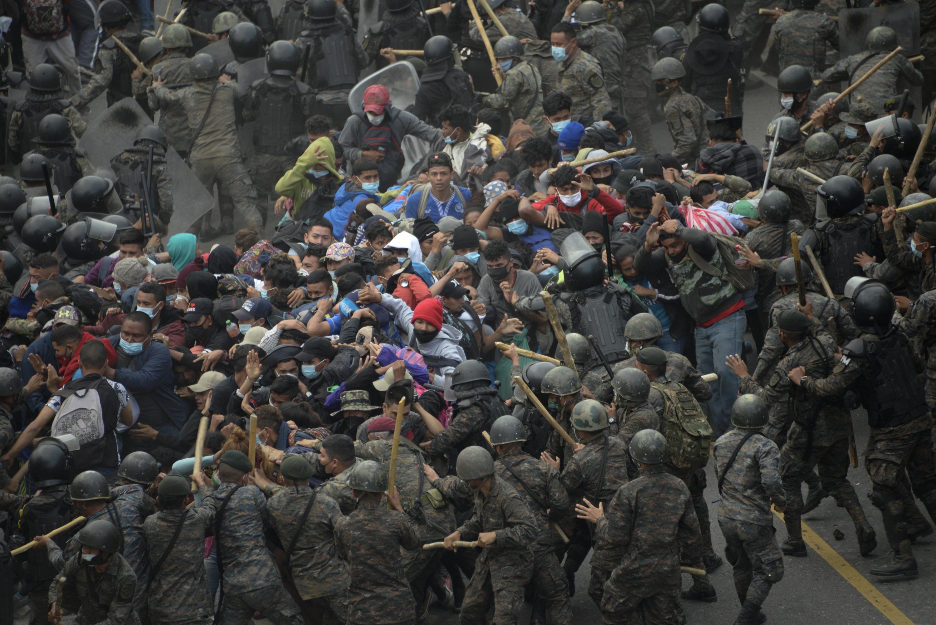 La caravana de migrantes hondureños choca con fuerzas de seguridad guatemaltecas, en Vado Hondo, Guatemala, el 17 de enero de 2021. La policía usó gas lacrimógeno para tratar de dispersar a la caravana. Foto: Johan Ordóñez / AFP.