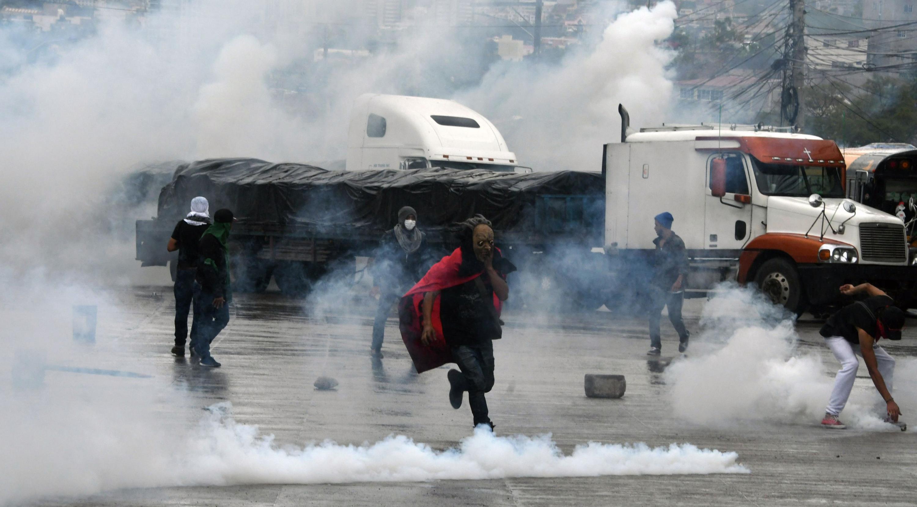 Manifestantes que apoyan al candidato de la oposición, Salvador Nasralla, se enfrentan con el ejército hondureño y policías en una de las protestas en Tegucigalpa, la capital del país, el lunes 18. AFP PHOTO/ORLANDO SIERRA