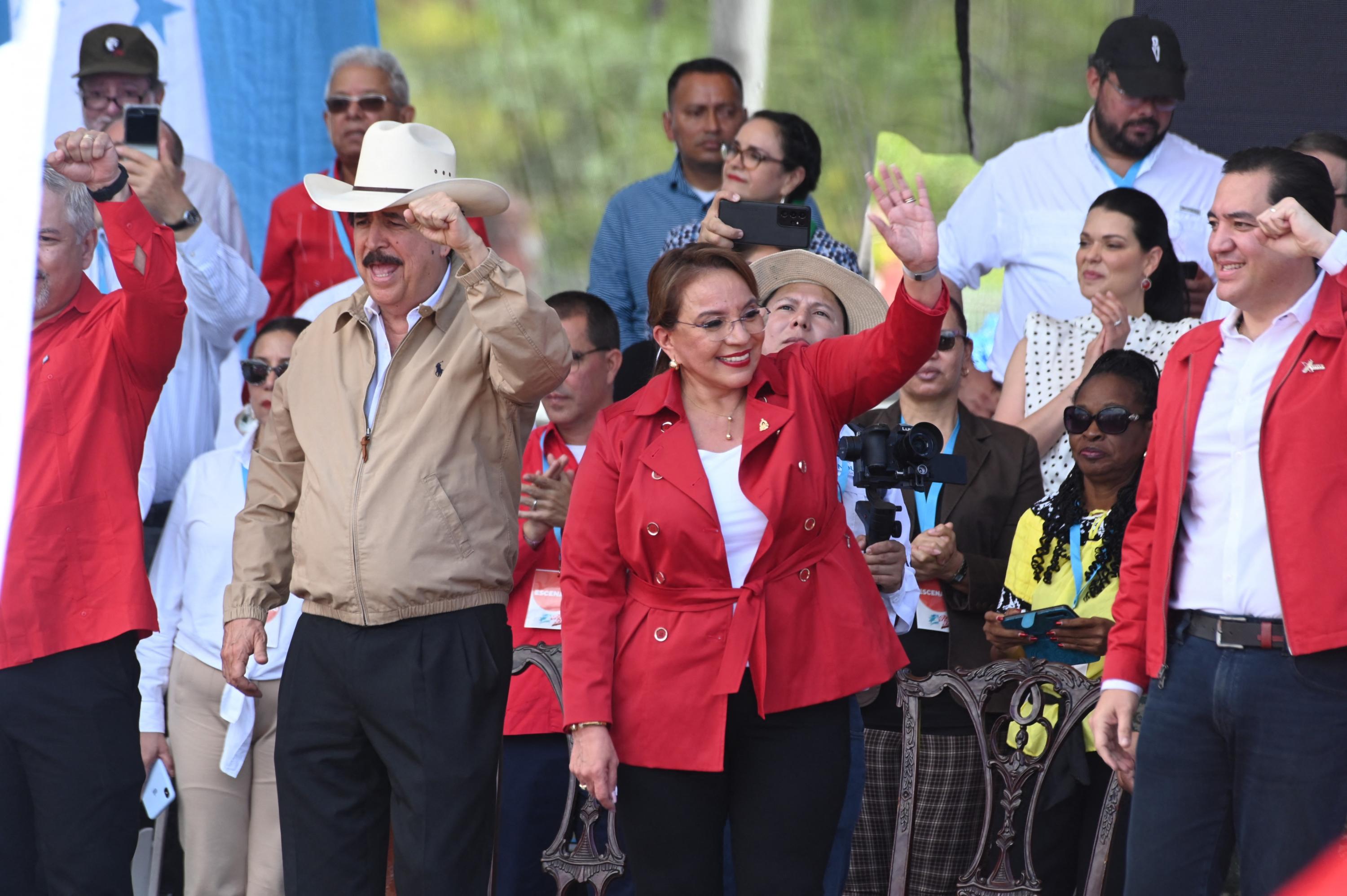 Honduran President Xiomara Castro, her husband and advisor Manuel Zelaya (left) and her son and private secretary Hector Manuel Zelaya (right) greet supporters during a demonstration to celebrate the second anniversary of Castro