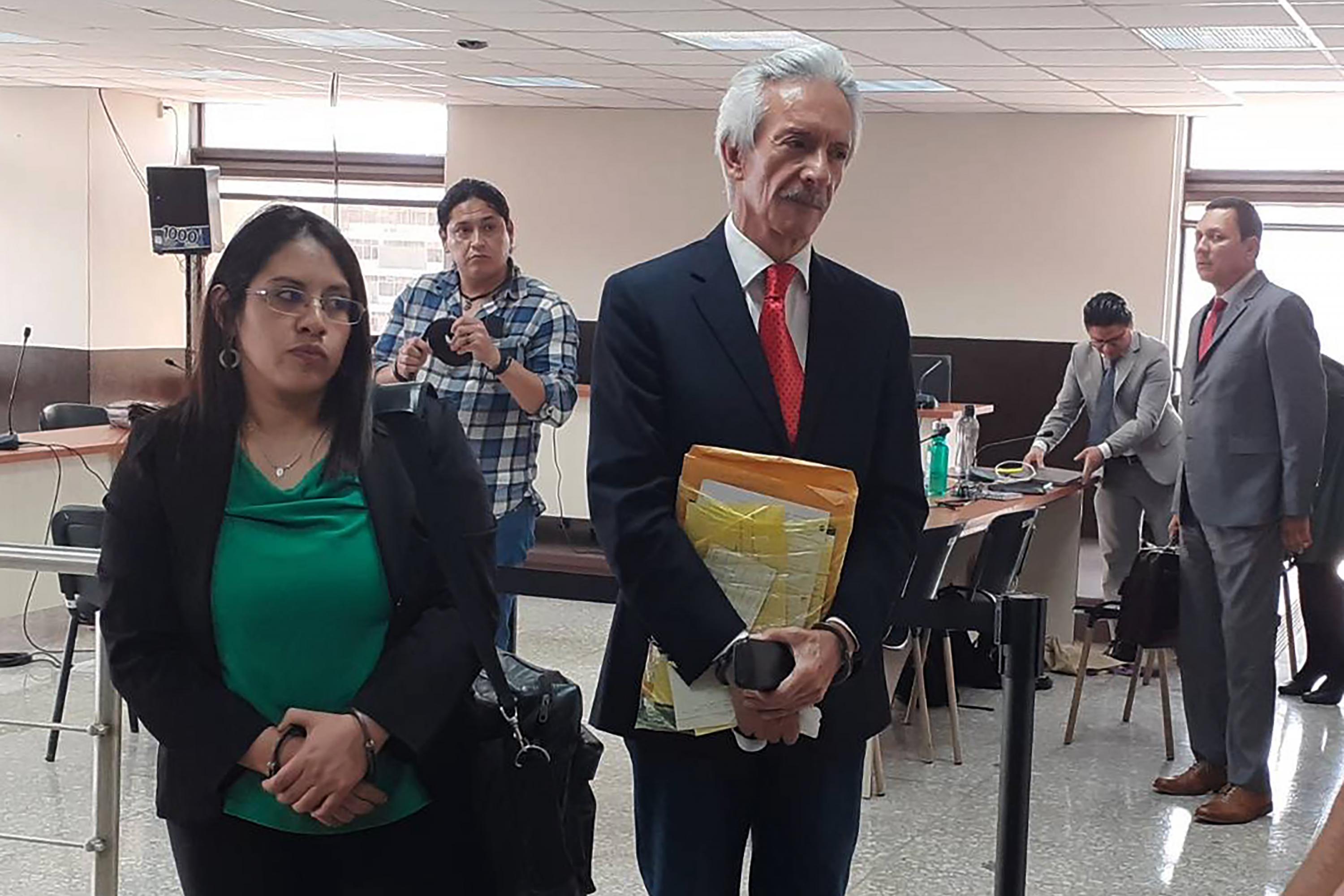 José Rubén Zamora (center) speaks with the press during his trial in May 2023 alongside former prosecutor Samari Gómez, accused in the same case of allegedly leaking confidential case information to Zamora. Raúl Falla (far right), lawyer for the Foundation Against Terrorism and the attorney of key state witness Ronald García Navarijo, watches in the background. Photo Julie López