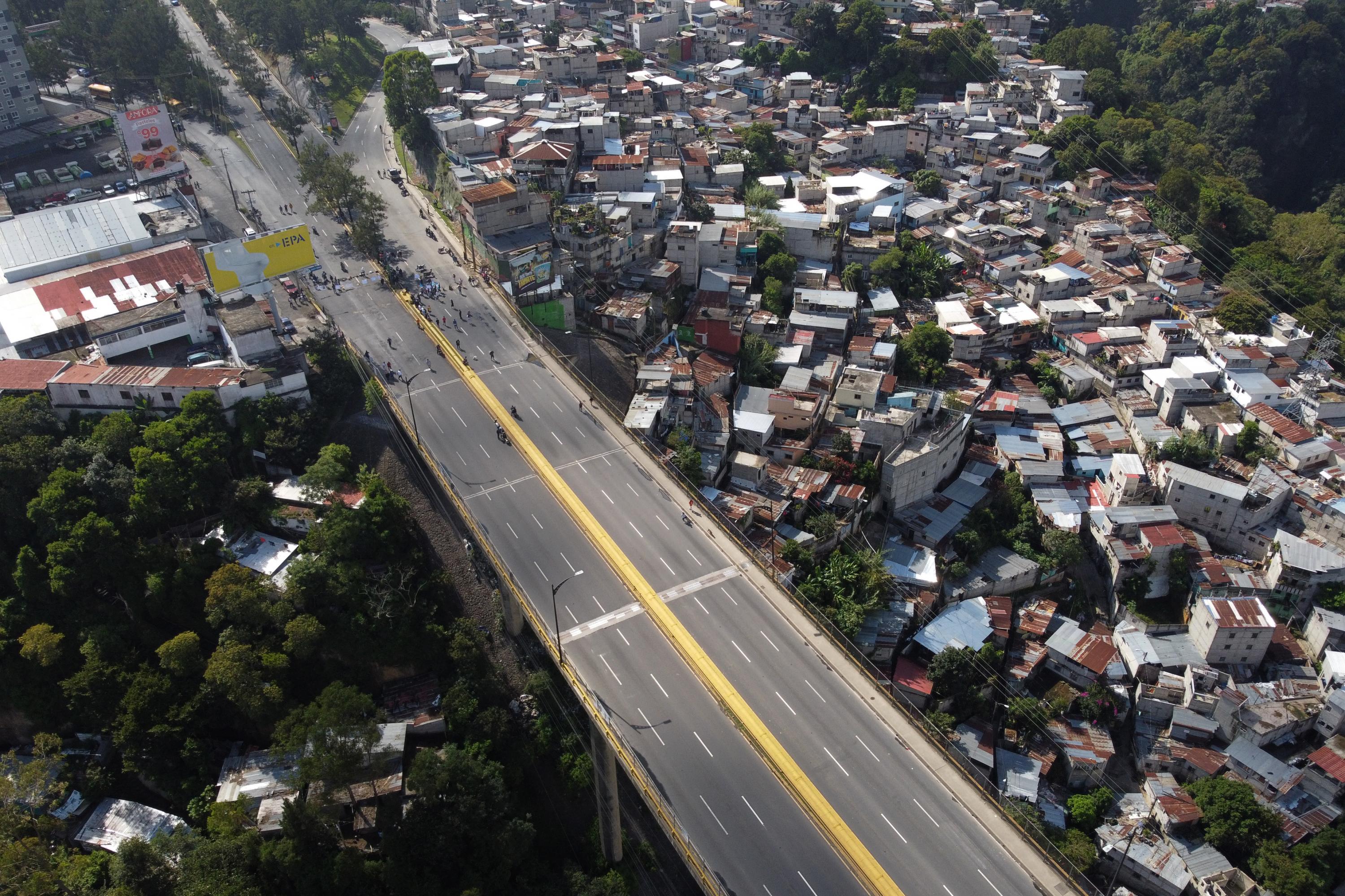 Manifestantes bloquean el puente El Incienso, sobre el Anillo Periférico de Ciudad de Guatemala, para exigir la renuncia de la fiscal general Consuelo Porras el 9 de octubre de 2023. Esta es una de las vías de acceso con mayor circulación en la capital. Foto de El Faro: Johan Ordóñez/AFP