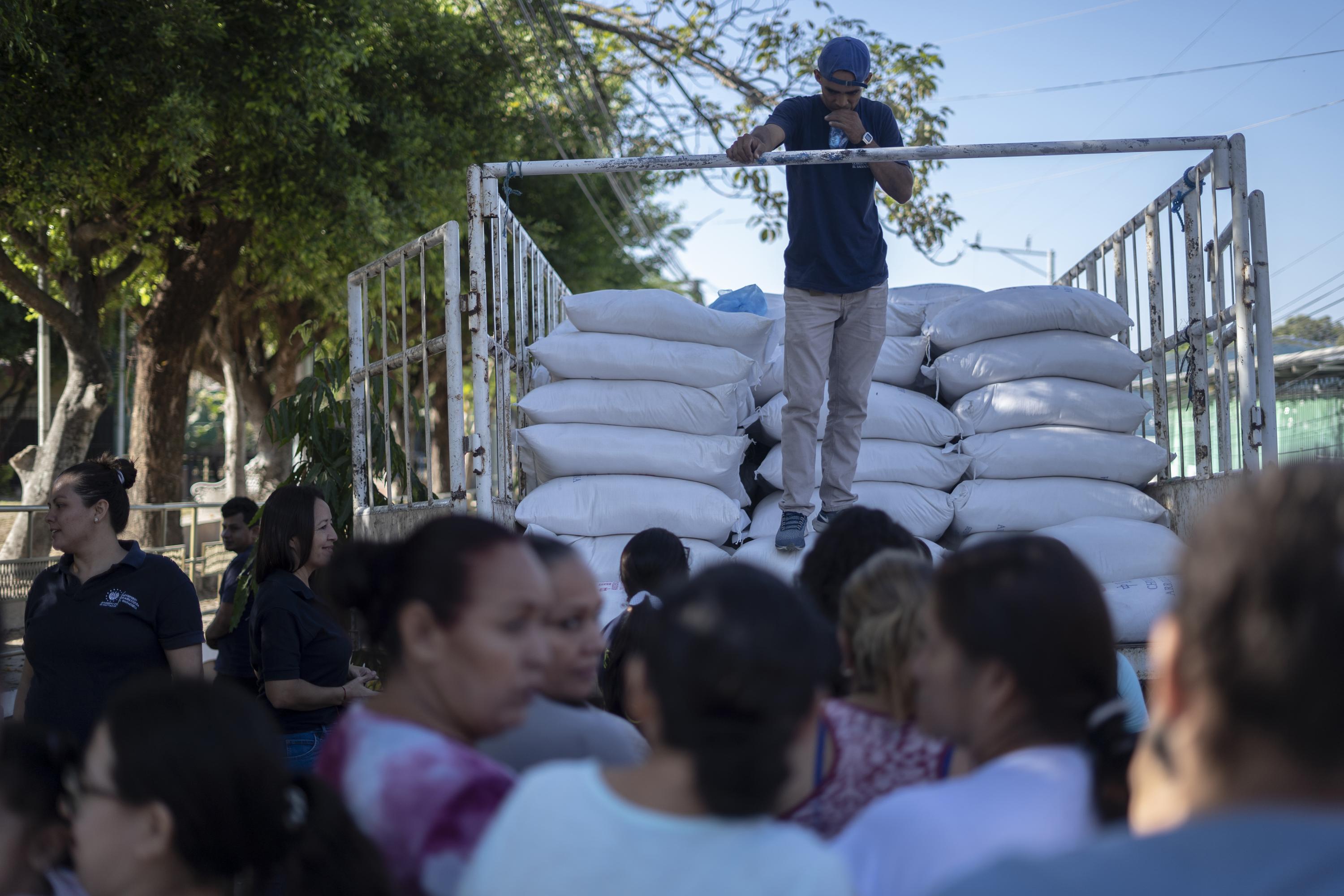 Empleados del Ministerio de Agricultura y Ganadería reparten sacos de arroz a los habitantes del municipio de San Rafael, departamento de Chalatenango, el miércoles 24 de enero.