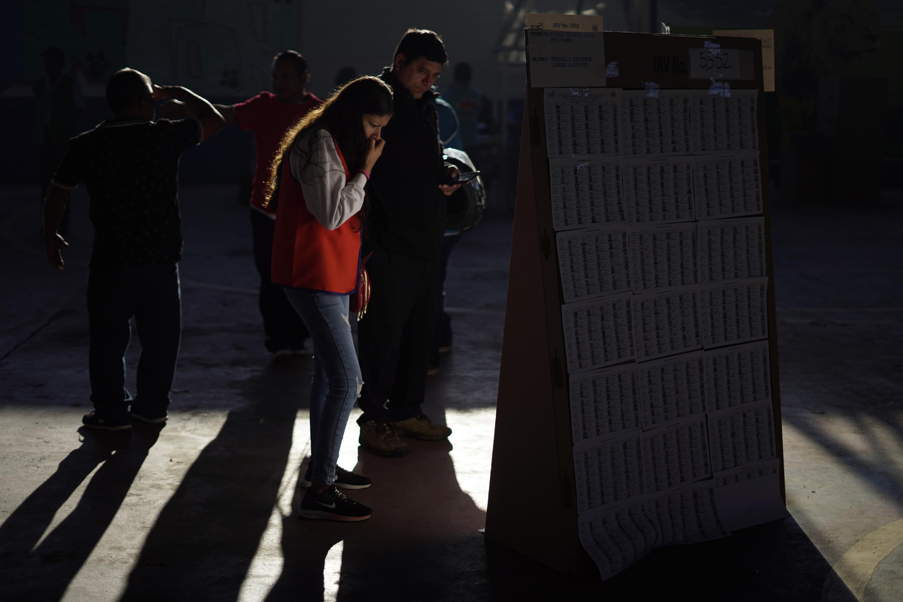 Votantes buscan su registro para emitir su voto en el Complejo Educativo Pedro Félix Cantor, del municipio de Izalco, en el departamento de Sonsonate, este 4 de febrero de 2024. Foto de El Faro: Víctor Peña. 