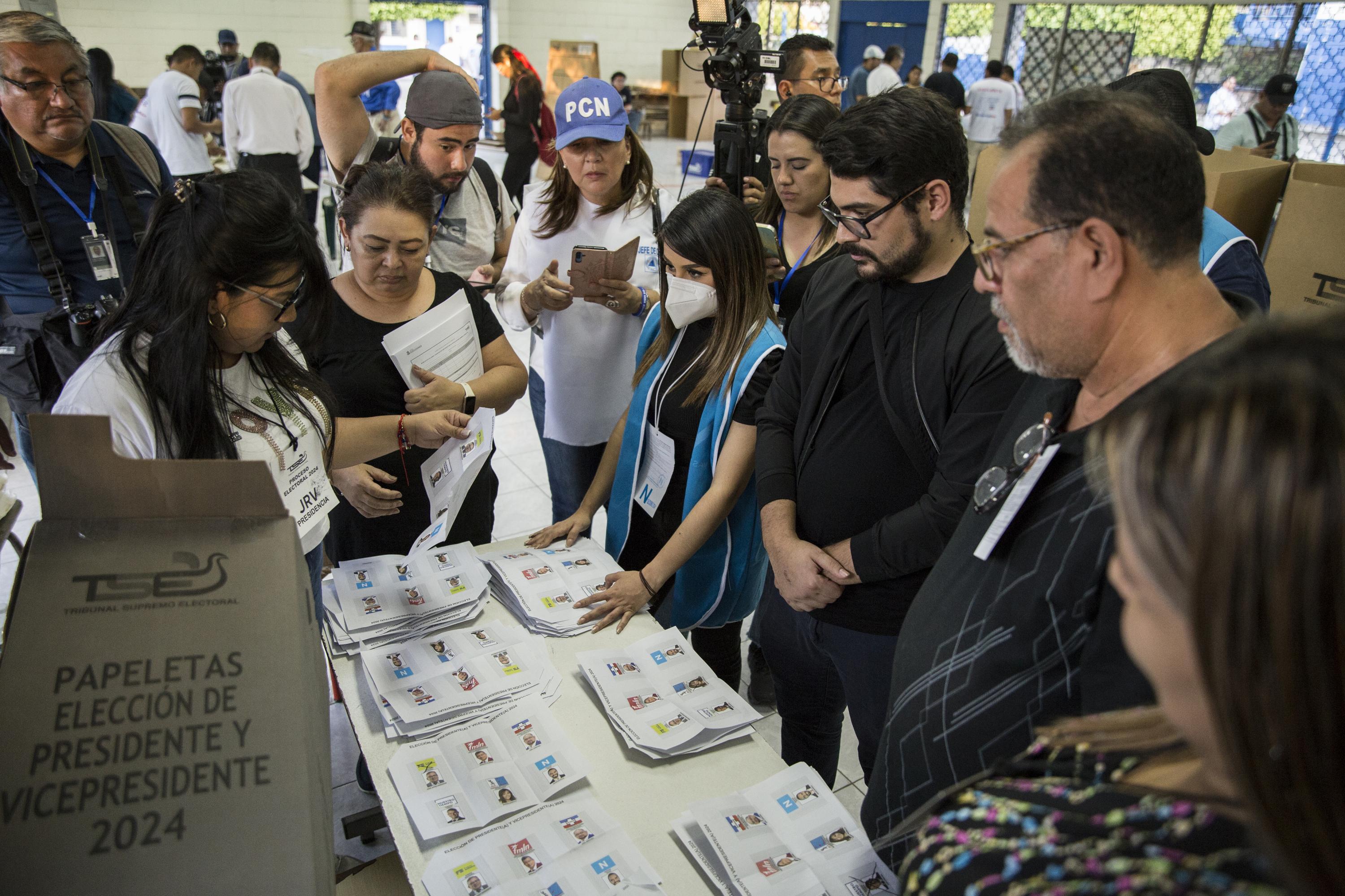 Members of voting stations count paper votes at the Walter Deninger voting center in Antiguo Cuscatlán. Photo Víctor Peña