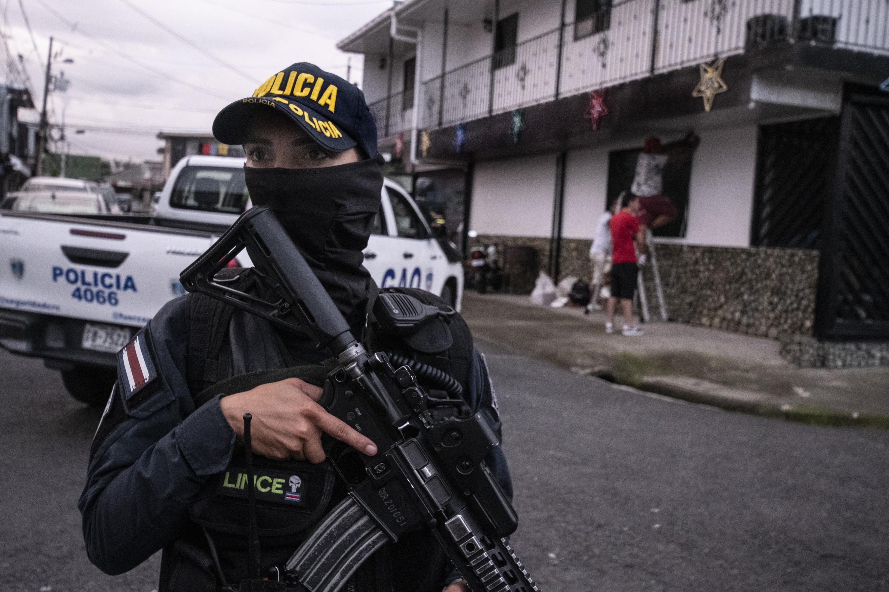 A Costa Rican police officer stands guard during an anti-drug operation in San José on October 28, 2023. Authorities had recorded 743 homicides to date that year, already making 2023 the most violent on record. Total homicides rose to 908 through December. Photo Ezequiel Becerra/AFP