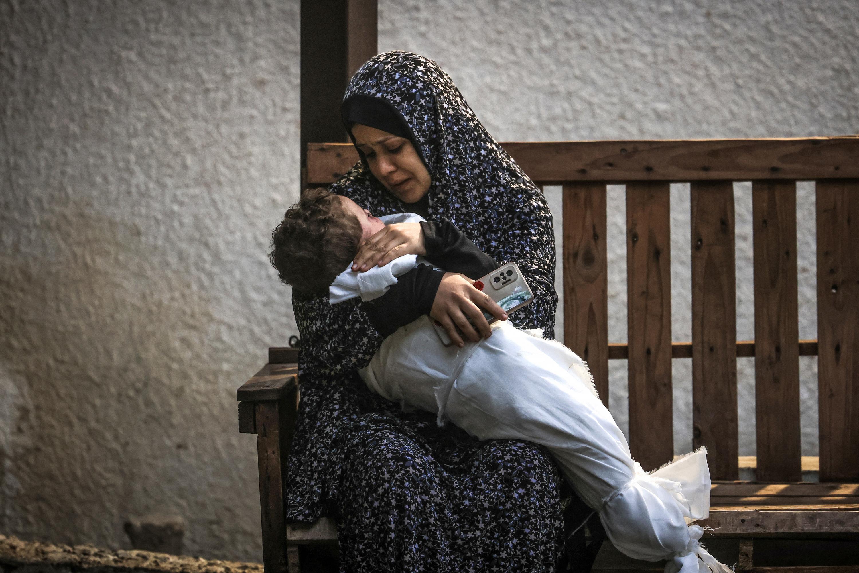A woman from the Palestinian Ashour family holds the body of a baby who was killed in Israeli bombardment, on December 14, 2023, at Najar hospital in Rafah, in the southern Gaza Strip, amid ongoing battles between Israel and the Palestinian militant group Hamas. Photo Mahmud Hams/AFP
