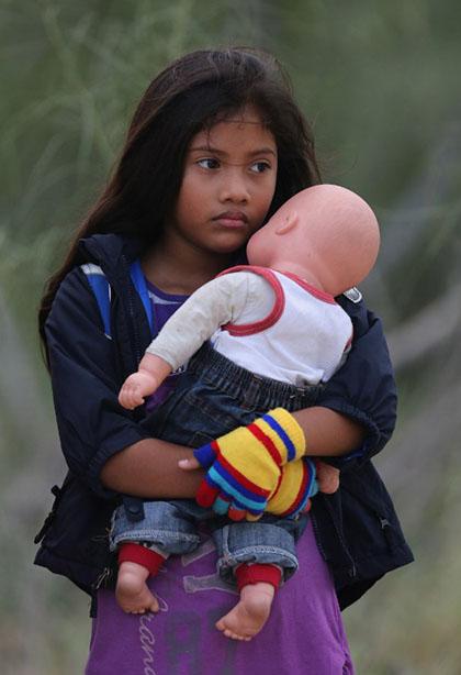 MISSION, TX - JULY 24: Una niña salvadoreña sostiene a su muñeco Rodrigo después de ser capturada por la patrulla fronteriza al cruzar el río Grande en Mission, Texas. Foto John Moore/Getty Images/AFP
