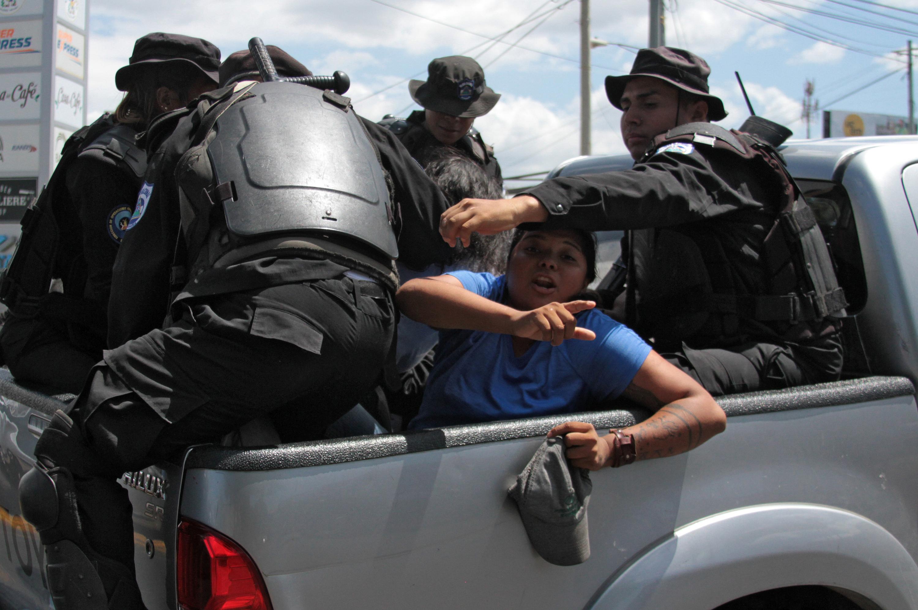 Agentes de la policía antidisturbios de Nicaragua arrestan a dos personas mientras se dirigían a una manifestación convocada por grupos de la oposición para exigir al gobierno la liberación de los detenidos por participar en protestas antigubernamentales en Managua el 16 de marzo de 2019. (Foto de Maynor Valenzuela / AFP)