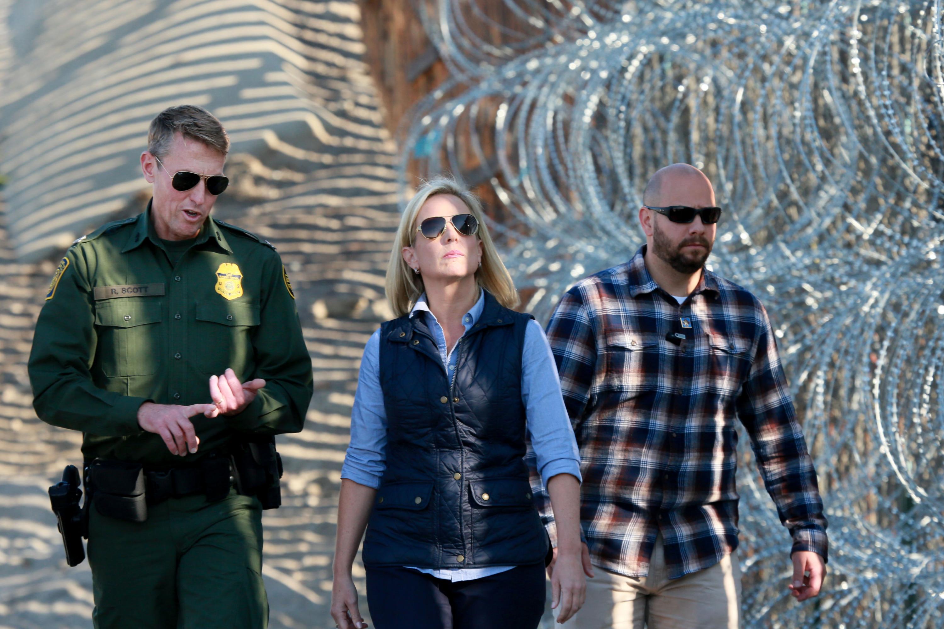 Kirstjen Nielsen (centro), ahora ex secretaria de Seguridad Nacional de Estados Unidos, camina por una sección de la frontera entre Estados Unidos y México en San Ysidro, California, el 20 de noviembre de 2018. (Foto: Sandy Huffaker/ AFP)