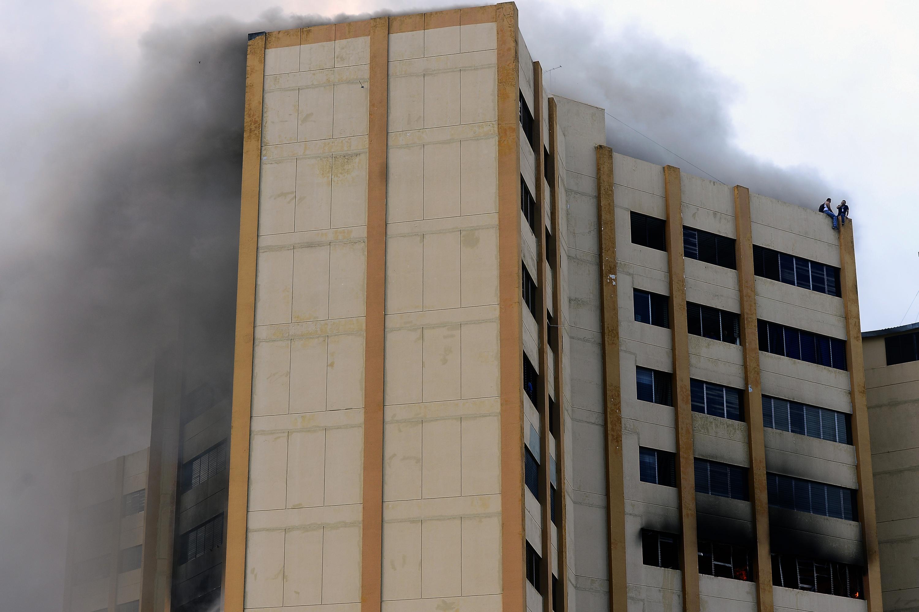 Dos trabajadores del Ministerio de Hacienda huyeron del humo y las llamas y se refugiaron en la azotea de la torre tres del edificio. Ambos fueron evacuados por un helicóptero de la Fuerza Aérea, y trasladados hacia el Hospital Militar, donde fueron atendidos por la inhalación de gases tóxicos.  / AFP PHOTO / Marvin Recinos