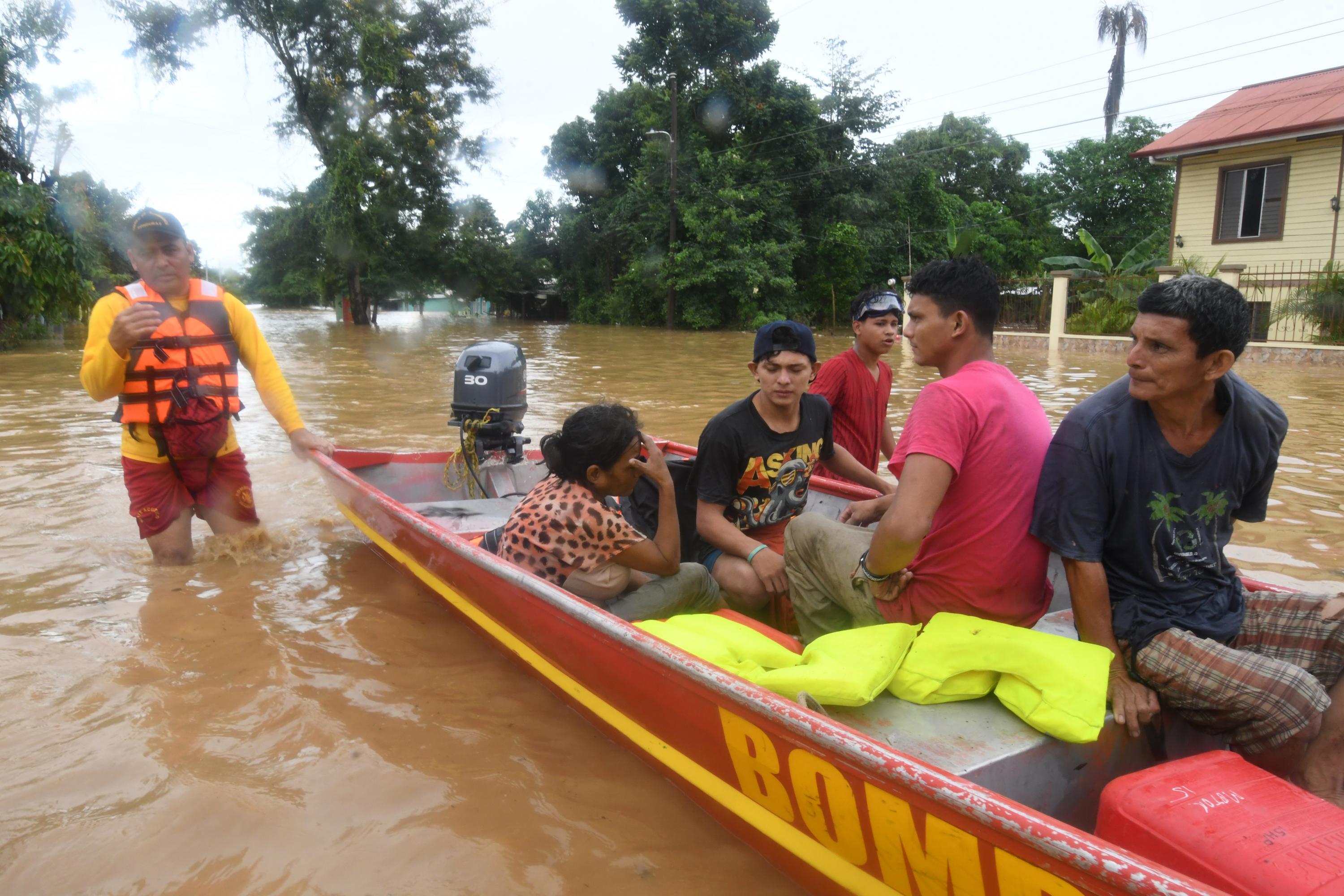 Bomberos rescatan a pobladores locales luego del desborde del río Ulúa en el municipio de El Progreso, departamento de Yoro. Foto de Orlando Sierra / AFP