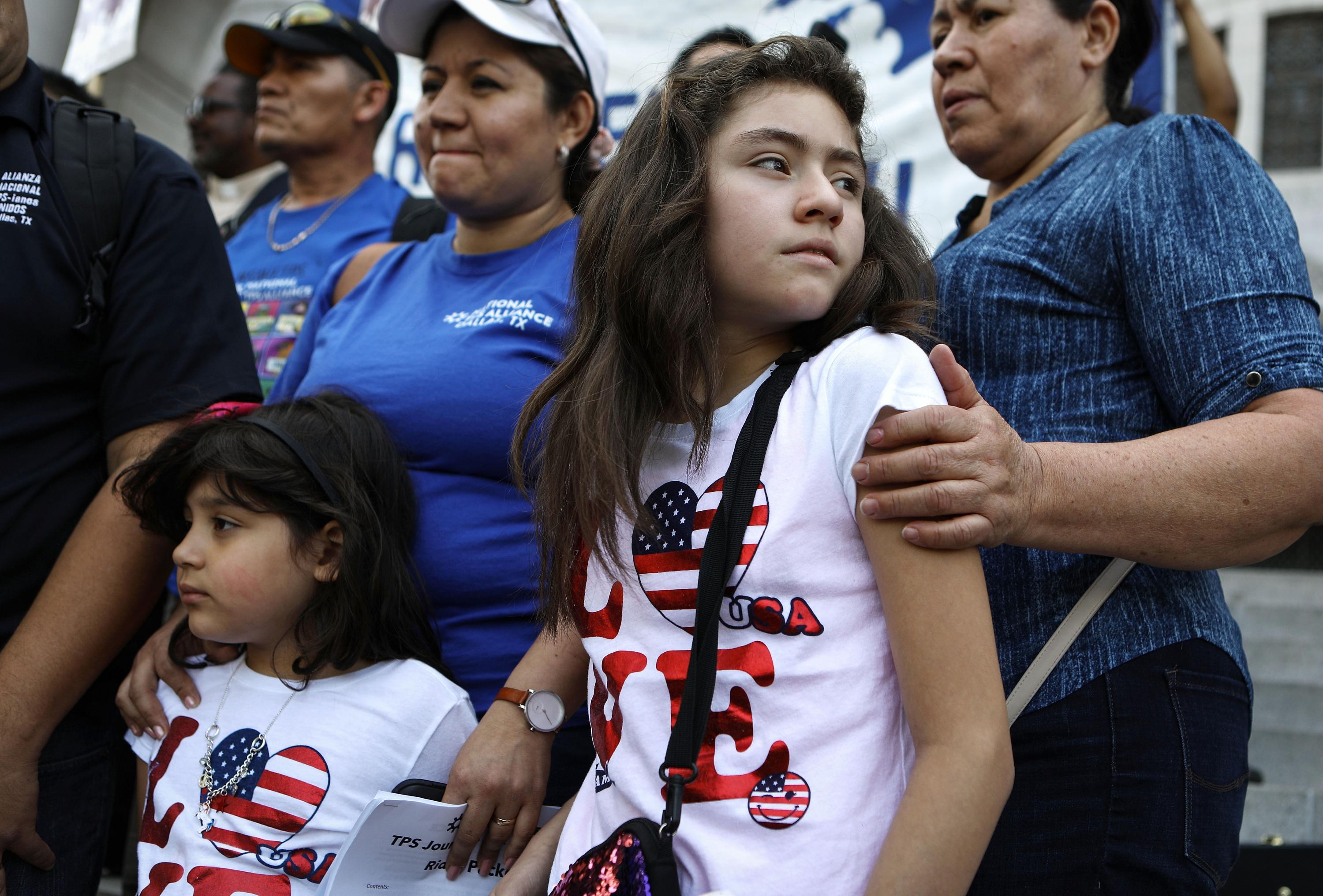 Mily Rivas (al centro), una beneficiaria salvadoreña de TPS,  junto a sus hijas Suri y Ariely Murillo, ambas ciudadanas de Estados Unidos, de pie en una protesta por el TPS afuera de la municipalidad de Los Ángeles, el 17 de agosto de 2018. Foto: Mario Tama/Getty Images/AFP