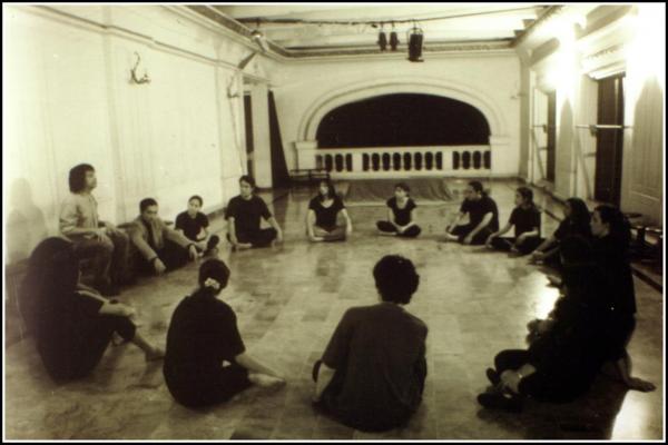 Filánder Funes, sentado en un banco dirige uno de los ejercicios con sus alumnos en la escuela Arte del actor (1998). 