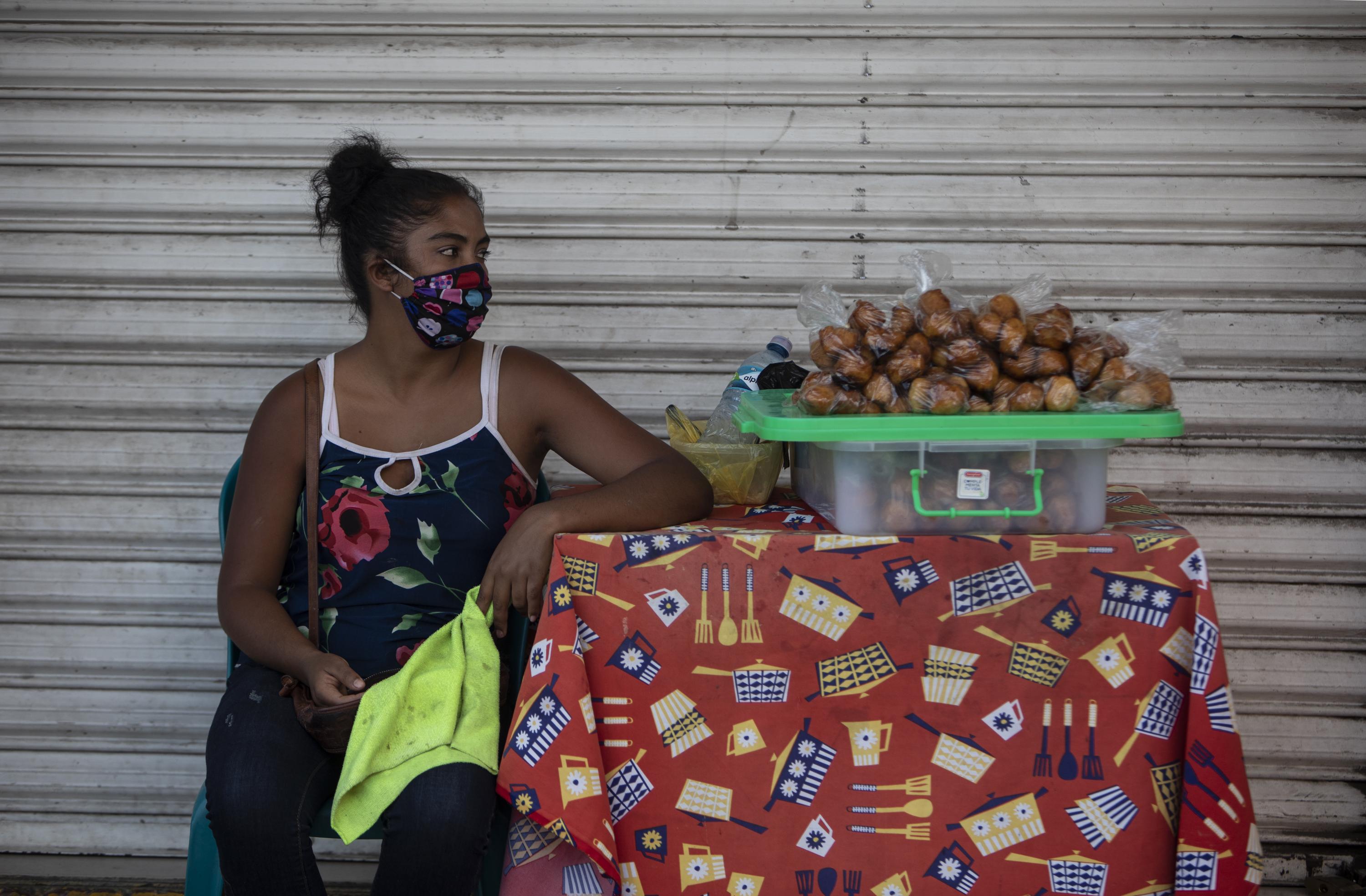 A woman wearing a face masks sells food in Nicaragua