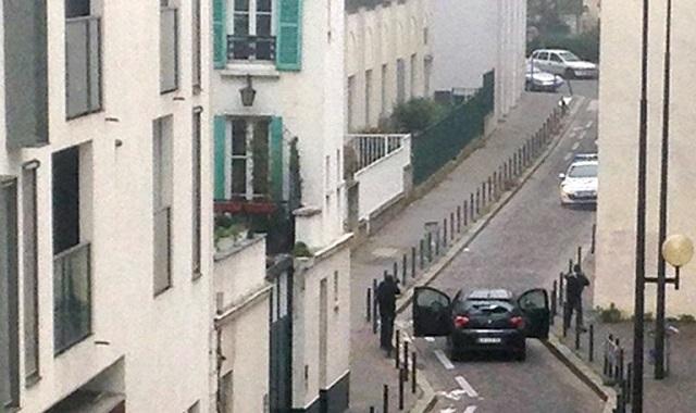 Dos hombres armados con fusiles de asalto momentos antes de asesinar a dos agentes de policía, tras perpetrar el atentado contra el semanario Charlie Hebdo, en París, Francia. Foto Anne Gelbard (AFP).
