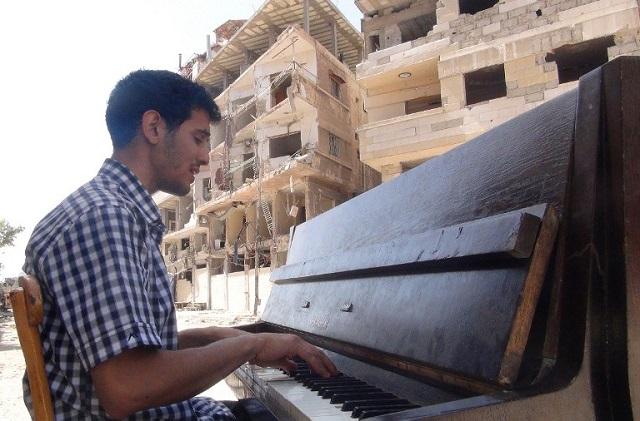 Imagen del pianista Aeham al-Ahmad tomada en junio de 2014, cuando aún se encontraba en en el campo de refugiados Yarmuk, en las afueras de Damasco. Hoy es uno de los miles de refugiados sirios que demabulan por Europa central. Foto Rami Al-Sayed (AFP).