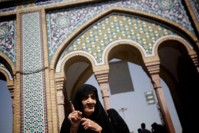 Una anciana iraní levanta su dedo manchado con tinta indeleble después de votar durante la primera ronda de las elecciones presidenciales en un centro de votación cercano al mausoleo de Shah Abdolazim, en Teherán, la capital de Irán. Foto archivo El Faro.