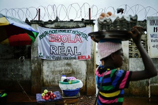 Una mujer camina frente a una pancarta en Freetown (Sierra Leona) que advierte del peligro del ébola, que ha provocado más de 8,000 muertos en África occidental. Foto archivo El Faro.