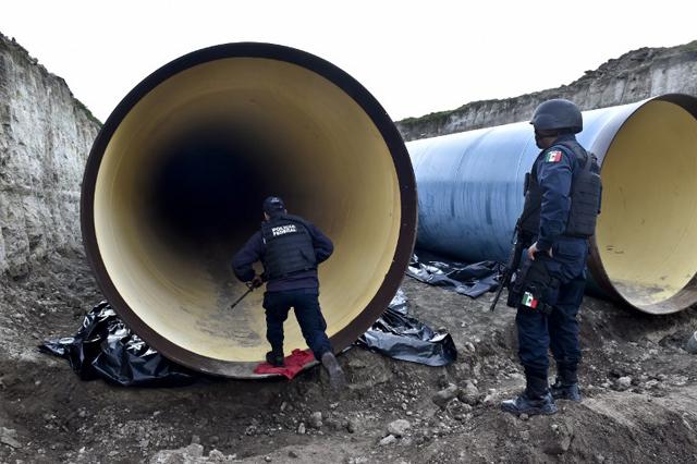 Policías federales mexicanos inspeccionan un oleoducto en construcción cerca de la prisión del Altiplano en Almoloya de Juárez, México, de donde ha escapado el capo mexicano Joaquín 