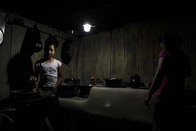 Una vez que se oculta el sol, María Cándida Amaya y Estela tienen que turnarse el uso de la lámpara de baterías si quieren moverse de un lugar a otro. Después de vivir 33 años en la comunidad Palo Verde, dicen que el servicio de energía eléctrica no les hace falta. 