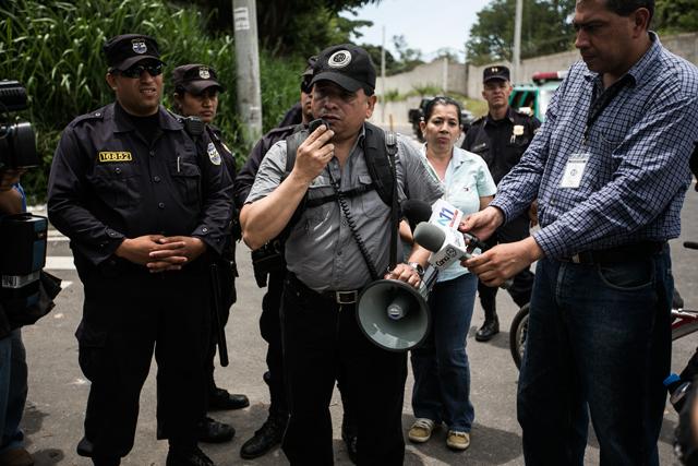 El juez de Paz de Antiguo Cuscatlán, José Palma Trejo, anuncia por megáfono, al mediodía del miércoles 3 de junio, que suspende el desalojo de la comunidad El Espino. Foto: Fred Ramos.