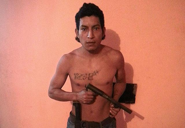 Miguel Ángel Tobar posa con un machete y un trabuco en un motel de Ahuachapán durante una entrevista realizada a mediados de este año.