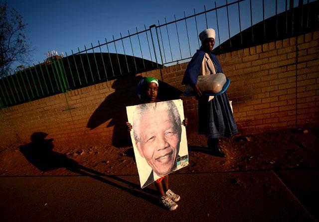 Una niña sostiene una foto de Nelson Mandela, fallecido el año pasado y considerado el padre de la nación sudafricana. Se cumplen 20 años del final del apartheid. Foto archivo El Faro.