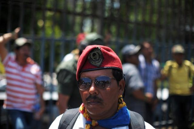 Un exsoldado luce orgulloso su gorra del Ejército de El Salvador durante la marcha que el miércoles 7 de agosto recorrió la alameda Juan Pablo II.﻿ Foto José Cabezas (AFP)﻿.