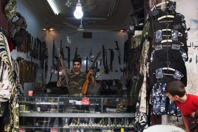 Abu Mohammad posa al interior de su armería en el barrio Fardus de Alepo. Los rebeldes del ESL son sus principales clientes, y el negocio, dice, va viento en popa. Foto JM López (AFP).
