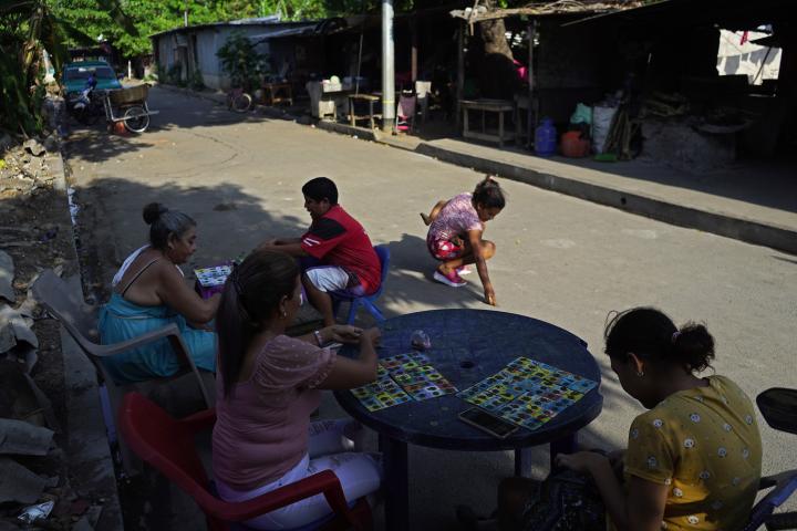 Habitantes del barrio Las Atarrayas juegan al bingo en la calle principal de esta comunidad del municipio de Acajutla, en el departamento de Sonsonate. Este barrio, junto a La Coquera, La Playa y la San Julián, era considerado uno de los más peligrosos de este municipio. Foto de El Faro: Víctor Peña.