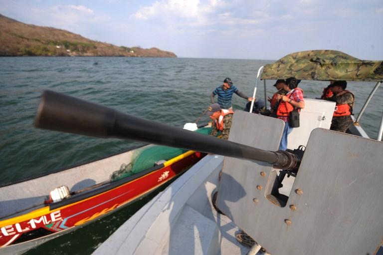 Soldados hondureños de una patrullera artillada conversan con pescadores artesanales con base en Amapala, en el golfo de Fonseca, cuyas aguas comparten Honduras, El Salvador y Nicaragua. Foto Orlando Sierra (AFP)﻿" /></div> <figcaption class=