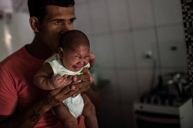 El joven Matheus Lima, de 22 años de edad, sostiene a su hijo Pietro, de dos meses, a quien se ha diagnosticado microcefalia, como consecuencia de que la madre padeció el zika durante los tres primeros meses de embarazo. Foto Christophe Simon (AFP).