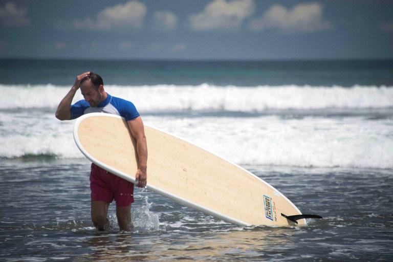 Un sufista regresa tras una práctica en la playa Jacó, en Costa Rica, que del 6 al 14 de agosto de 2016 acogerá el Mundial de surf, en medio de un fuerte repunte en la epidemia de virus del Zika. Foto Ezequiel Becerra (AFP).