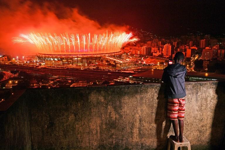 Un muchacho observa desde la favela Mangueira la clausura de los Juegos Olímpicos de Río de Janeiro 2016. Foto Carl De Souza (AFP).