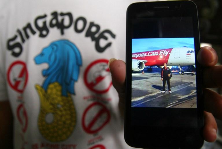 Un familiar sostiene un celular con una foto que fue tomada y enviada, supuestamente, antes de abordar el AirAsia Flight QZ8501, en Malang, en la isla de Java, el pasado 28 de diciembre. Foto: Aman Rochman (AFP).