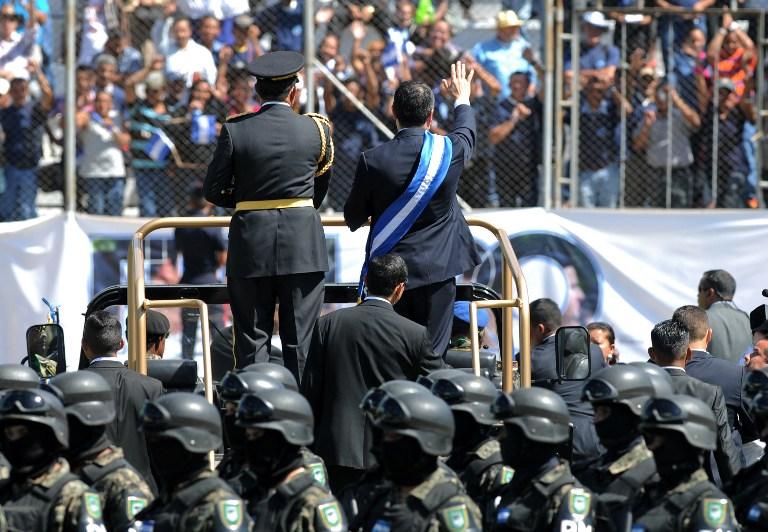 De espaldas, sobre el carro y con la banda presidencial, Juan Orlando Hernández, presidente de Honduras, durante la ceremonia de toma de posesión. Foto archivo El Faro.