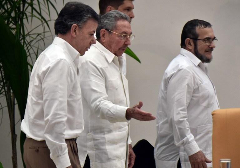 El presidente cubano Raúl Castro (centro), el presidente colombiano Juan Manuel Santos (izquierda) y el líder de las FARC, Timoleón Jiménez, alias ¨Timochenko¨ a su arribo a la reunión en la que anunciaron los logros en las negociaciones de justicia dentro del marco de los acuerdos de paz.  AFP PHOTO / Rodrigo ARANGUA