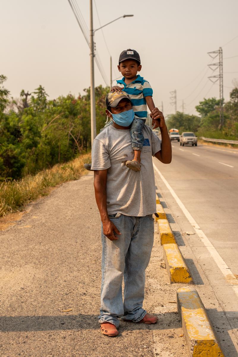 A father and son stand on the side of the street asking for help from passersby. Once the lockdown went into effect thousands of vulnerable people, without jobs or help from the government, flocked to the streets hoping the common citizen would empathize. San Pedro Sula. April, 20th, 2020. Photo: Seth Berry