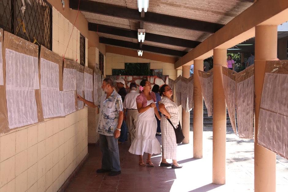 Votantes buscan el número de urna que les corresponde en el Instituto Nacional Francisco Menéndez, en San Salvador.