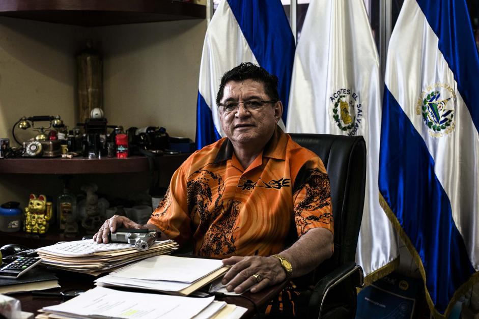 Catalino Miranda, with a gun on his desk in San Salvador, owns a fleet of buses and refuses to yield to extortion demands. Fred Ramos/El Faro for The New York Times