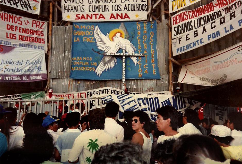 "The people's jubilee for achieving peace," reads one of the posters placed outside the San Salvador Cathedral on January 16, 1992, marking the celebration of the end of the war and the signing of the Chapultepec Peace Accords. Photograph taken by ex-guerilla fighter Guillermo Alfredo Olivares, who passed away in 2009. The signs document the widespread distrust in the signing government's willingness to uphold the historic agreement.