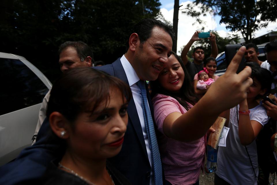 El Candidato a la presidencia Jimmy Morales se toma una fotografía con simpatizantes, en el instituto Ave María, Mixco, Guatemala. Foto: Fred Ramos